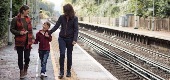 A family walking along the platform of a rural train station