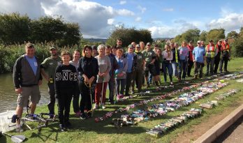 Litterpick volunteers stand behind the litter they have picked and sorted