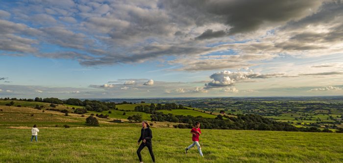Kids playing in a field under a cloudy sky