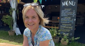 Mariella Frostrup sits on a bench at a festival