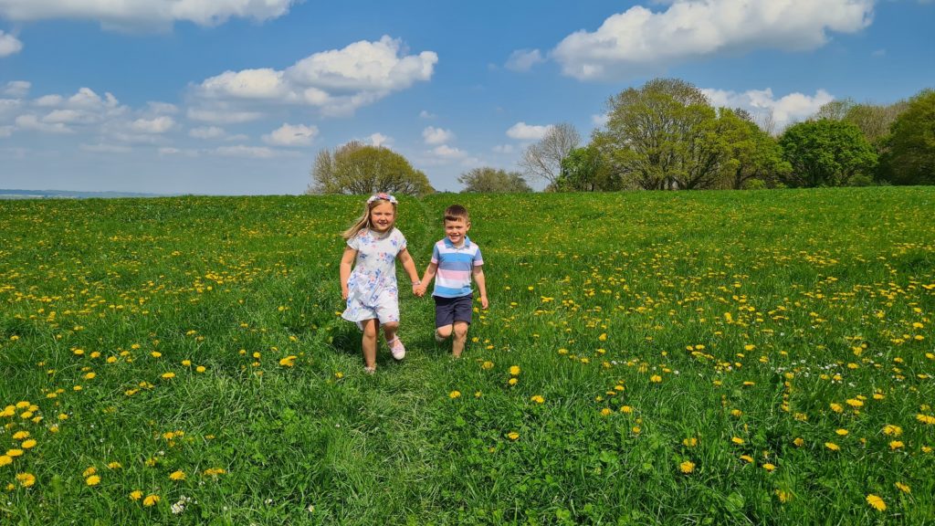 Two children play in a meadow