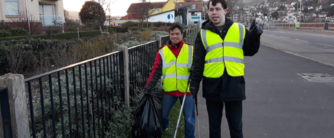 two people with hi-viz vests and litterpickers