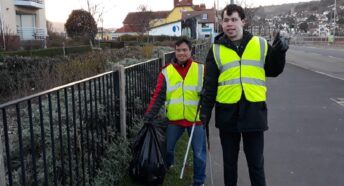 two people with hi-viz vests and litterpickers