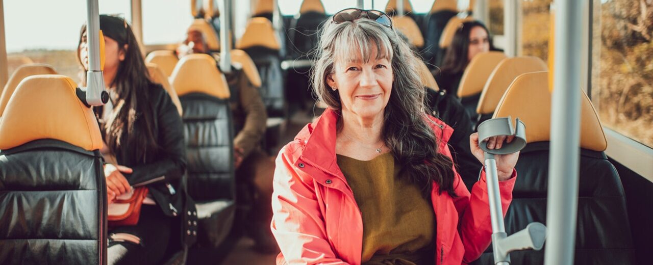 woman with crutch sitting on a bus