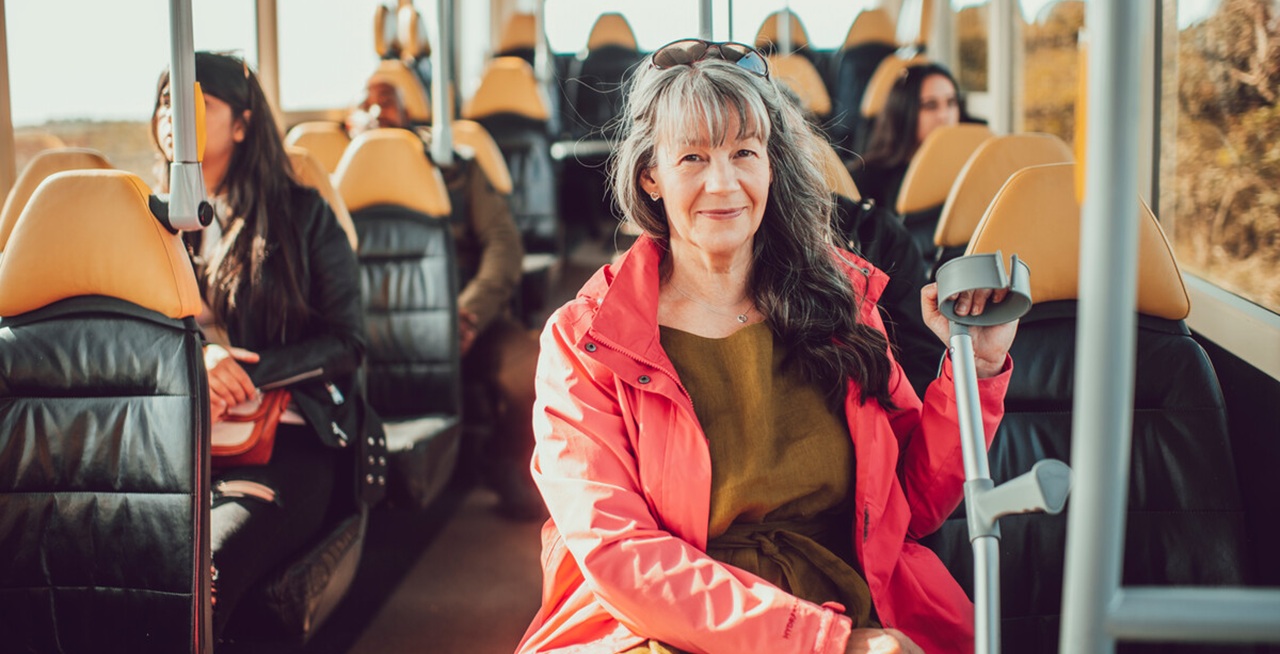 woman with crutch sitting on a bus