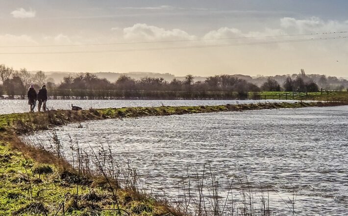 two people walking by flooded fields
