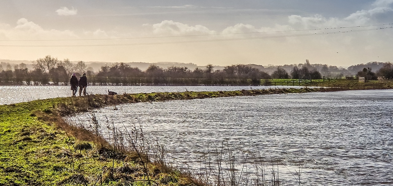 two people walking by flooded fields