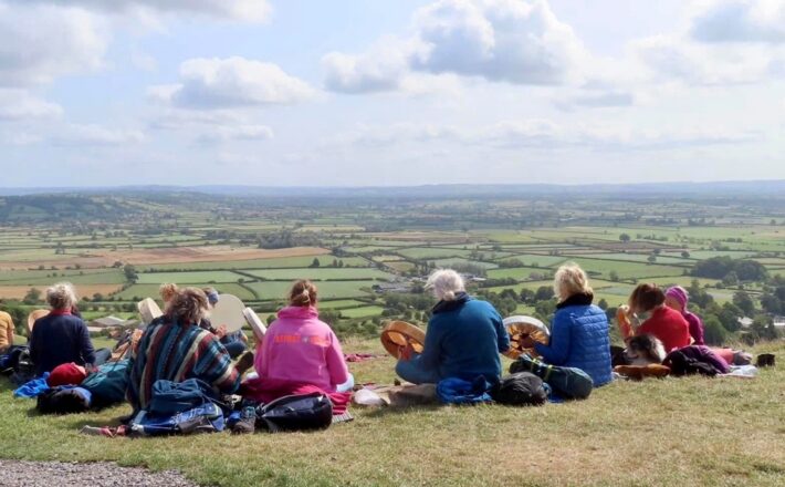 a group of people seated playing instruments and looking at the view