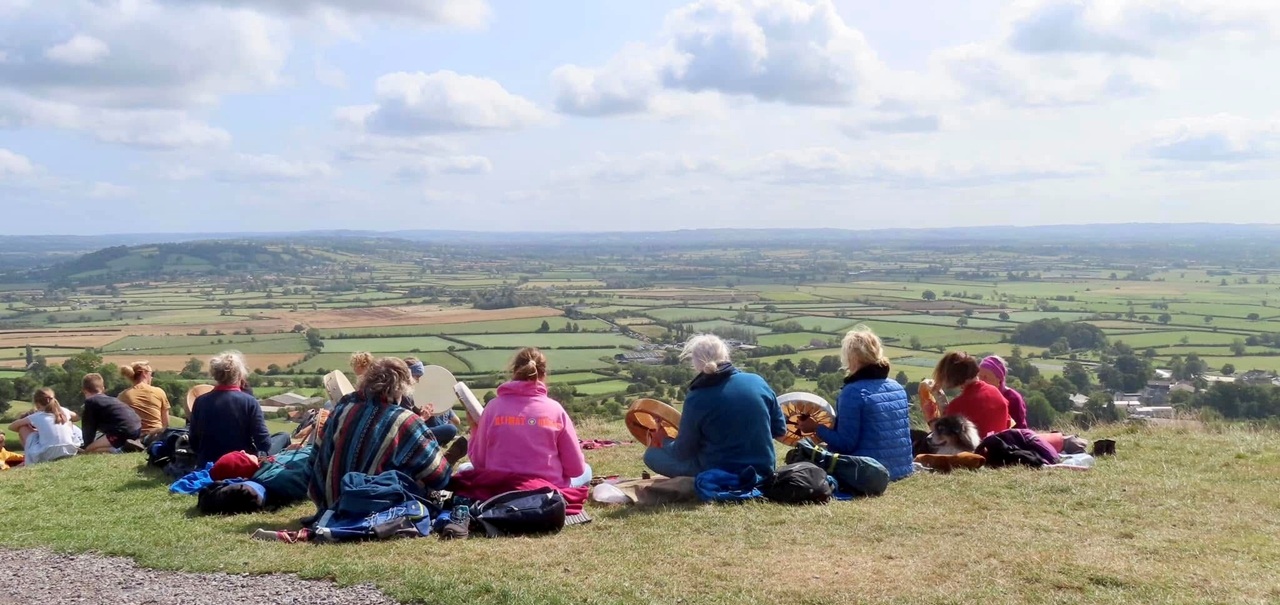 a group of people seated playing instruments and looking at the view