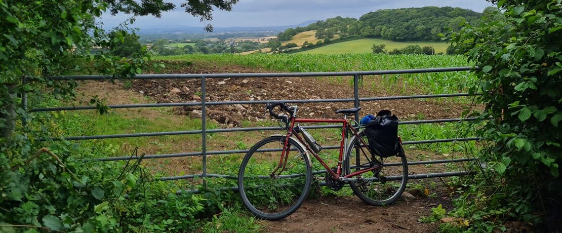 bike leaning against gatepost in countryside