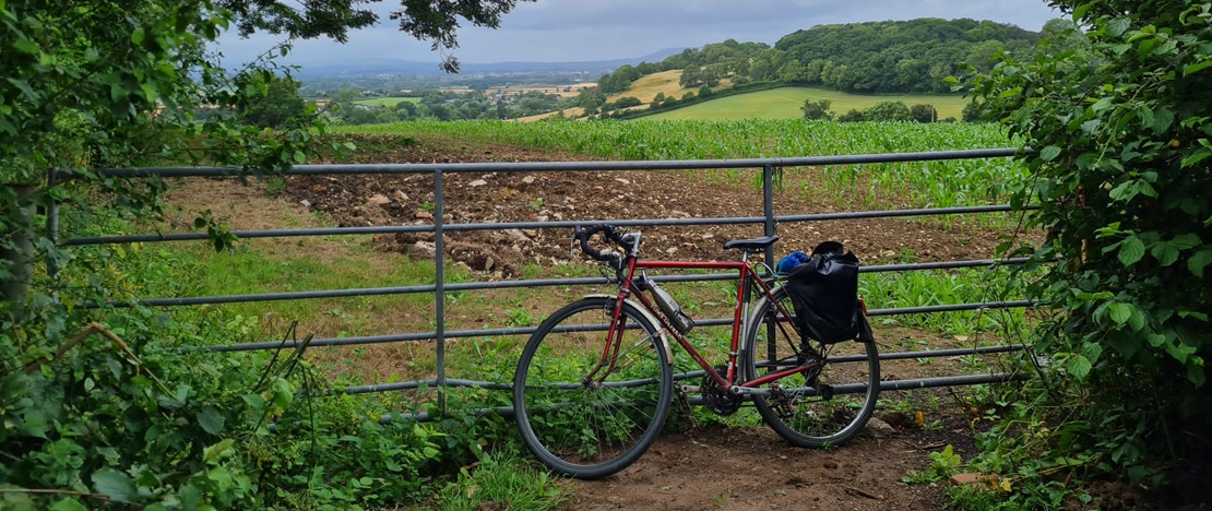 bike leaning against gatepost in countryside